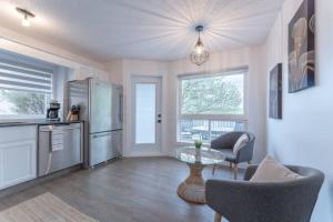 uma cozinha com um frigorífico, uma mesa e cadeiras em Chic Romantic3bed patio WIFI quiet retreat parking em Calgary