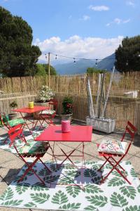 eine Terrasse mit 2 Tischen und Stühlen und einem Zaun in der Unterkunft Appartamento con terrazza a due minuti dal lago in Minusio