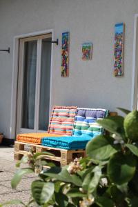 a bed with colorful pillows sitting next to a wall at Appartamento con terrazza a due minuti dal lago in Minusio