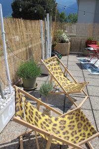 2 chaises avec des coussins à motifs léopards assis sur une terrasse dans l'établissement Appartamento con terrazza a due minuti dal lago, à Minusio