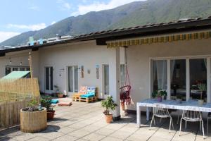 een huis met een tafel en stoelen op een patio bij Appartamento con terrazza a due minuti dal lago in Minusio