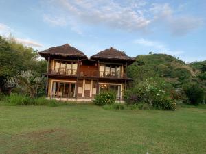 a large house with a large yard in front of it at Lombok Villas, Villa PaoPao in Labuhanpoh