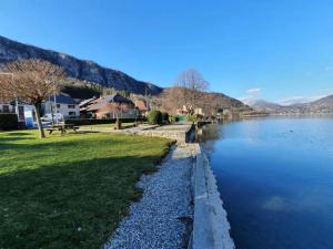 a view of a river with mountains in the background at LA MAISON DU LAC in Doussard