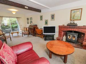 a living room with a red couch and a fireplace at 6 Glyn Terrace in Porthmadog