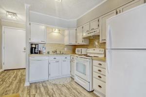 eine Küche mit weißen Schränken und einem weißen Kühlschrank in der Unterkunft Windy Village C-6 in Myrtle Beach