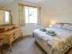 a bedroom with a bed and a dresser and a window at 6 Glyn Terrace in Porthmadog
