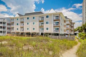 a large apartment building on the beach with a grass field at Windy Village C-6 in Myrtle Beach