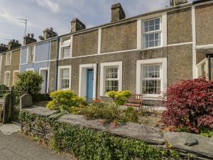 a house with a blue door and flowers in front at 6 Glyn Terrace in Porthmadog
