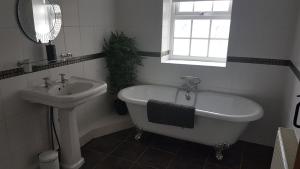 a bathroom with a sink and a bath tub and a sink at Bodrual cottage in Caernarfon +22 photos