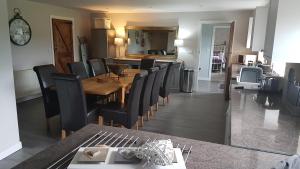 a dining room with a wooden table and black chairs at Bodrual cottage in Caernarfon