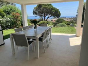 a dining room table and chairs on a patio at VILLA BLANCHE in Cavalaire-sur-Mer