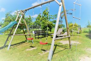 an empty playground with swings and a bench at Fewo 1 Mittendrin in Lancken-Granitz