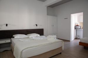 a white bedroom with a large bed with white sheets at Sea Breeze 2 Apartments in Mastichari