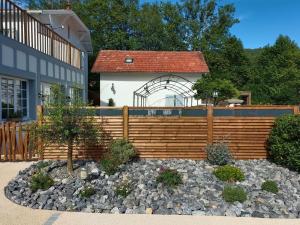 a wooden fence in front of a house at Logis Hostellerie du Neez in Gan