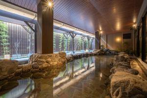 京都的住宿－Kyoto Umekoji Kadensho，一座建筑中一座带岩石的大型室内游泳池