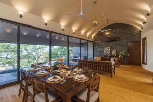 a dining room and living room with a table and chairs at SaffronStays Yahvi Waters by Kosha Villas, Pawna - pool villa with stunning lake view in Lonavala