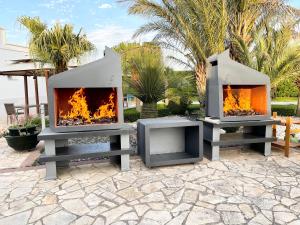 a fire pit with two fireplaces on a patio at Ferrocino Resort in Galatone