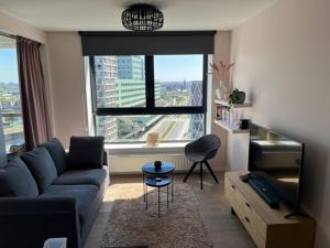 a living room with a blue couch and a large window at "VH apartment" - center of Antwerp - free parking in Antwerp