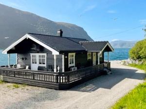 a house on the shore of a body of water at Three-Bedroom Holiday home in Selje 1 in Selje