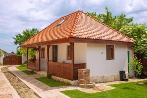 mały biały dom z pomarańczowym dachem w obiekcie Conacul Grigorescu w mieście Răteşti