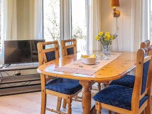a wooden dining room table with chairs and a television at 4 person holiday home in lyngdal-By Traum in Korshamn