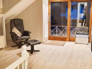 sala de estar con silla negra y taburete en 7 person holiday home in Bokn, en Are