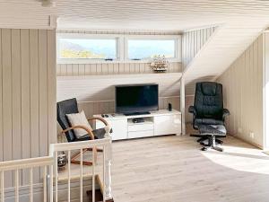 a living room with two chairs and a television at 7 person holiday home in Bokn in Are