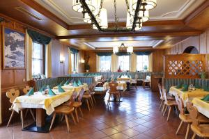 アンベルク・イム・ランマータールにあるSalzburger Dolomitenhofのテーブルと椅子、シャンデリアのあるレストラン