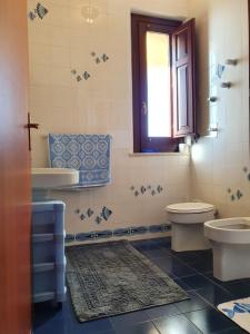 a bathroom with a sink and a toilet and a window at Villino Maria Elena in Valderice +51 photos