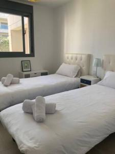 a bedroom with two beds with towels on them at Appartement Casares - Mer, Golf, Piscine, Padel - FINCA CORTESIN in Estepona