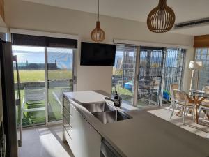 a kitchen with a sink and a view of a table at Dolphin Shores in Corlette