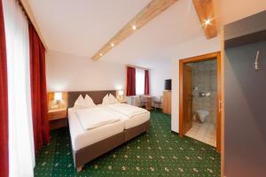 a hotel room with a bed and a bathroom at Salzburger Dolomitenhof in Annaberg im Lammertal