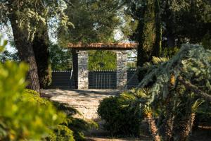 a stone archway with a fence in a garden at Otto Apulia House B&B in Andria