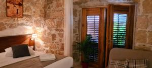 a bedroom with two beds and a window with a plant at San Teodoro in Korčula