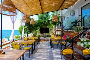 um restaurante com mesas e cadeiras e vista para o oceano em Siro Kerma Private Beach Villa em Sarandë
