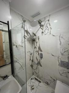 bagno con doccia in marmo e lavandino di Didim Elit Otel a Didim