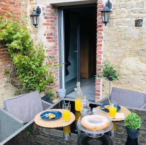 een tafel met eten en drinken op een patio bij Les Chambres d'hotes de Sophie in Piennes