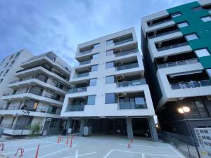 two apartment buildings with a tennis court in front at Ela's Apartment in Mamaia Sat/Năvodari