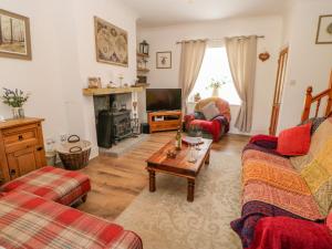 a living room with two couches and a tv at Grace Cottage in Bishop Auckland