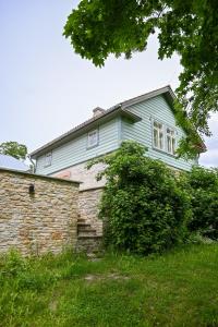 a blue house with a stone wall at Haapsalu Kunstikooli hostel in Haapsalu