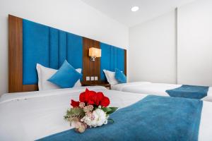 a hotel room with two beds with a bouquet of flowers at اطلالة الشرفة 1-Terrace View 1 in Al Khobar