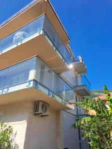 a house with a glass balcony on the side of it at Apartments with sea view in Prcanj in Kotor