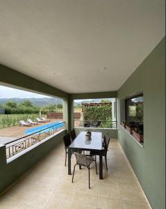 - une salle à manger avec une table, des chaises et une piscine dans l'établissement Thespis Villa 1, à Sikia