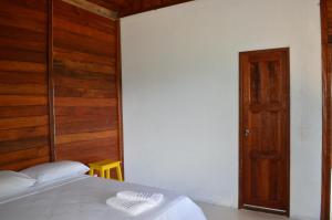 a bedroom with a bed and a wooden wall at Aldeia Mari-Mari Amazon Lodge in Presidente Figueiredo