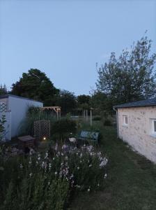 - un jardin avec un banc et des fleurs dans la cour dans l'établissement charmant studio 35m² au calme proche du circuit, à Saint-Gervais en-Belin