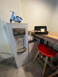 a small refrigerator with a red chair next to a table at 樸宿民宿 in Guanshan +14 photos