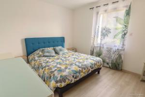 um quarto com uma cama com uma cabeceira azul e uma janela em LES 7 ÎLES em Baden