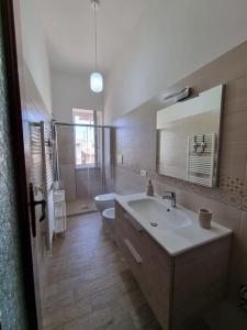 W łazience znajduje się umywalka, toaleta i lustro. w obiekcie Bella D'Estate - 10 minutes from the beach w mieście Ischia