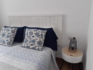 a bedroom with a bed with blue and white pillows at Apartamentos Cotillo Family in El Cotillo