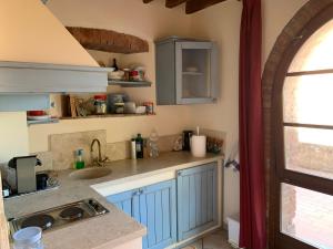 una cocina con armarios azules y fregadero en Casa Elisa, en La Bandita